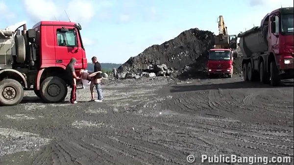 A very cute blonde young lady is fucked in public threesome at a construction site